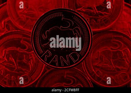 Cinque monete di Rand dal Sudafrica con più di cinque monete di Rand sullo sfondo. Foto Stock