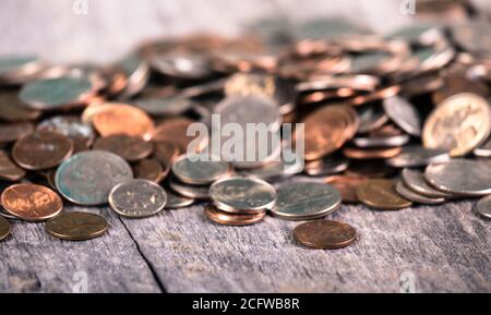 Primo piano di un assortimento di vecchie monete che giacciono su un tavolo di legno Foto Stock