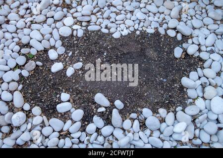 letto di pietre bianche arrotondate e lisce raggruppate insieme al centro apertura dello sporco Foto Stock