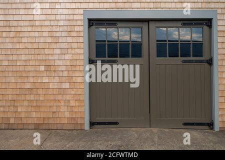 due grandi fienile verde oliva porte in legno con vetri Foto Stock