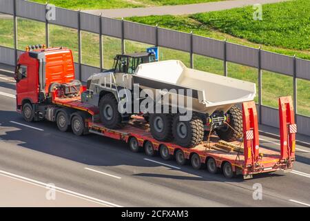 Trasporto di un camion enorme per l'estrazione mineraria sul rimorchio piattaforma Foto Stock