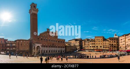 Pittoresco panorama del famoso Palazzo pubblico con il campanile Torre del Mangia, nella storica Piazza del campo in una giornata di sole... Foto Stock