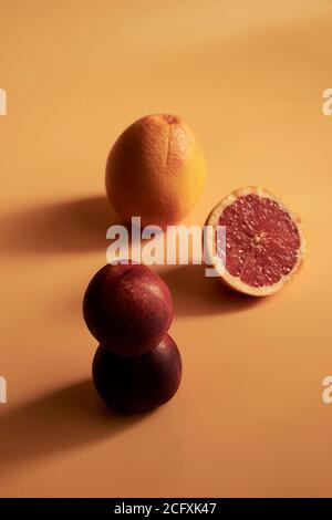 Ancora vita di due pesche su uno sfondo arancione. Foto Stock