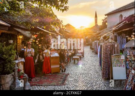 Strada acciottolata con caffè e negozi di souvenir nel centro storico di Mostar, BiH Foto Stock