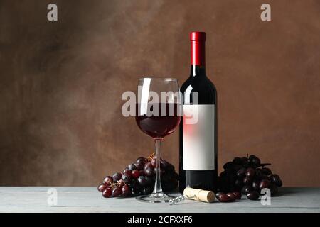 Composizione con vino, sughero e uva su sfondo marrone Foto Stock