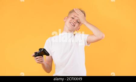 Sad boy che gioca a videogiochi in studio Foto Stock