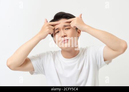 Concetto di cura della pelle dell'uomo. Acne punto pimple macchia macchia cura di bellezza maschio che preme sulla faccia di problema di pelle. Foto Stock