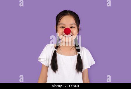 Ragazza kid coreana divertente che indossa il naso di Clown, Studio Shot Foto Stock