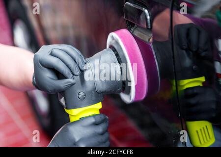 Uomo con macchina lucidatrice carrozzeria auto Foto Stock