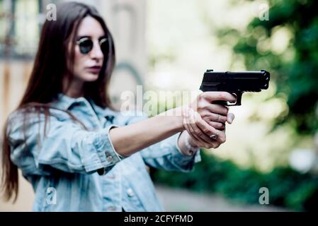 l'istruttore di tiro della ragazza prende lo scopo con una pistola al sito Foto Stock