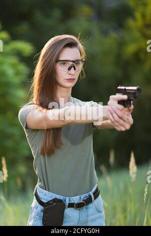 l'istruttore di tiro della ragazza prende lo scopo con una pistola al sito Foto Stock