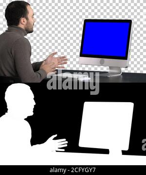 Giovane uomo d'affari che fa videochiamata sul suo computer, canale Alpha. Schermata blu di Mock-up Display. Foto Stock