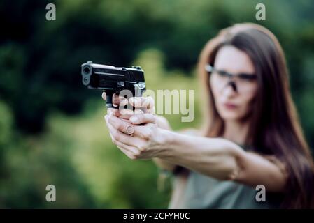 l'istruttore di tiro della ragazza prende lo scopo con una pistola al sito Foto Stock