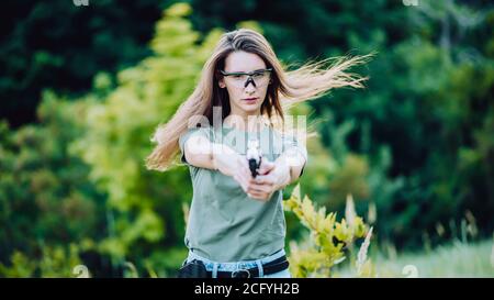 l'istruttore di tiro della ragazza prende lo scopo con una pistola al sito Foto Stock