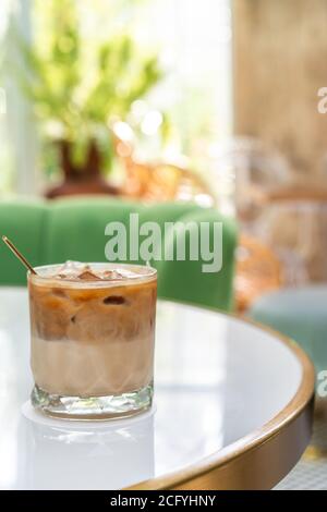 Ghiaccio in un bicchiere alto con latte versato Foto Stock