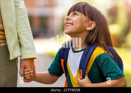 Madre che porta la figlia a scuola Foto Stock