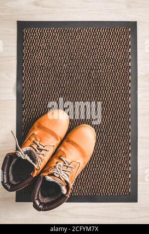 Scarpe marrone camoscio da donna su un tappeto sul pavimento nel corridoio. Foto Stock