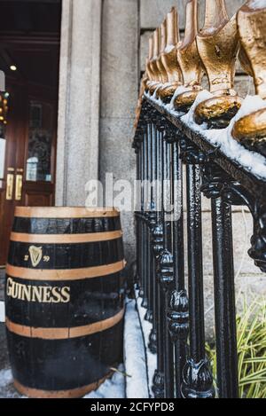 Tradizionale corrimano irlandese a punta, nero con una barile di birra Guinness all'ingresso di un pub. Tipico recinto irlandese a passo nero con barile di birra Foto Stock