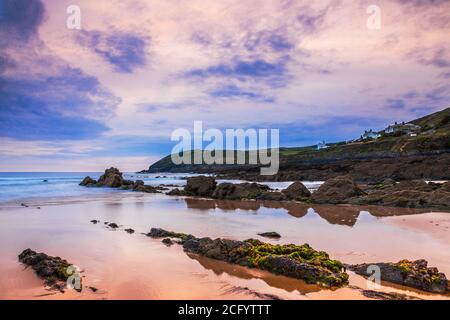 Vista al crepuscolo delle rocce degli strati e del canale di Bristol al tramonto da Croyde Bay, North Devon, Inghilterra, Regno Unito. Foto Stock