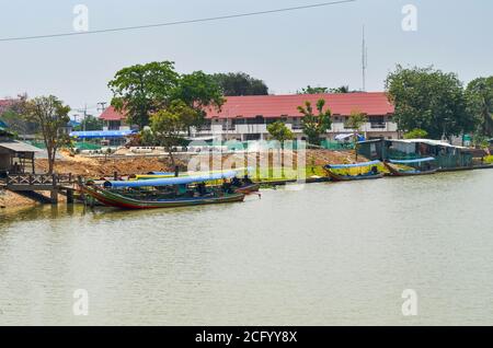 Riva rurale del fiume Chao Phraya con il tradizionale transito tailandese barche vicino alla stazione della funivia per attraversare il fiume Foto Stock