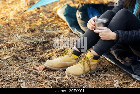 Tagliata di donna seduta in tenda da sola, bevendo tè Foto Stock