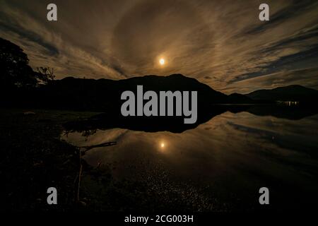 Moon Halo sopra Ullswater nel distretto lacustre inglese una notte nuvolosa Foto Stock