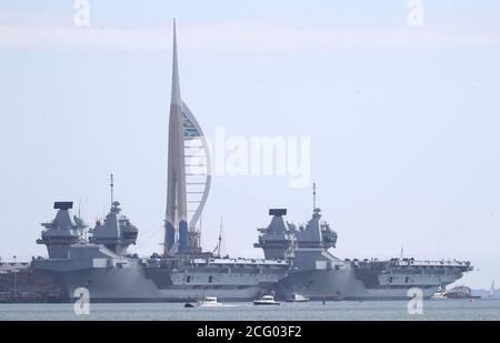 Le compagnie aeree della Royal Navy HMS Prince of Wales (a sinistra) e la HMS Queen Elizabeth attraccarono l'una accanto all'altra a HMNB Portsmouth. La partenza della Royal Navy Aircraft Carrier HMS Queen Elizabeth dalla base navale per gli esercizi di addestramento in mare è stata posticipata per il secondo giorno di fila dopo che un certo numero di membri dell'equipaggio ha provato positivo per Covid-19. Foto Stock