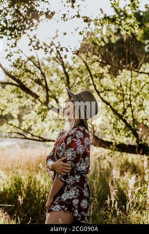 ritratto verticale di una giovane donna che guarda in alto cielo e sorridente Foto Stock