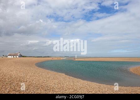 Shingle Street, Suffolk, Regno Unito - 8 settembre 2020: Cottage bianchi e una laguna blu sulla spiaggia di pietra. Foto Stock