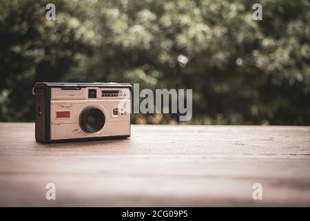 Vecchia e usurata fotocamera dagli anni '60 in rustico tavolo di legno Foto Stock