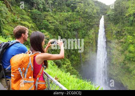 Coppie di turisti sulle Hawaii dalla cascata Akaka cade su Big Island, Hawaii, Stati Uniti. Foto Stock