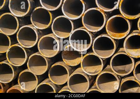 Pila di nuovi tubi in metallo. Materiale industriale. Foto Stock