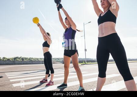 Gruppo funzionale avente un allenamento fitness con kettlebell nello sport palestra Foto Stock