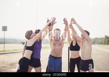 Felice giovane gente atletica in sportswear dando alta cinque in palestra Foto Stock