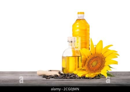 Bottiglie di olio di girasole con semi e girasole su legno tavolo isolato su sfondo bianco Foto Stock