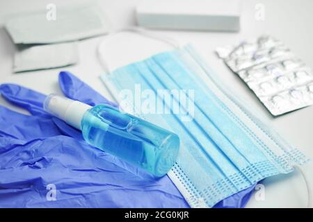 maschera, guanti, antisettici e pillole giacciono su uno sfondo bianco. Mezzi di protezione individuale Foto Stock