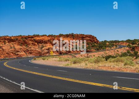 Una lunga strada dritta che conduce verso una montagna. Foto Stock