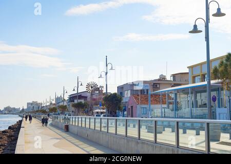 LARNAKA, CIPRO - FEB 18, 2019: Persone che camminano per Larnaca città argine con edifici tipici architettura in luminoso giorno di sole. Cipro Foto Stock