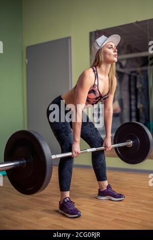 Athletic femmina modello fitness azienda heavy barbell e preparazione per deadlift. Foto Stock