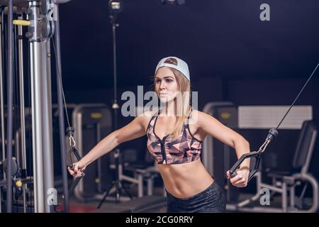 Fitness woman eseguire l'esercizio con la macchina ginnica Cable crossover in palestra Foto Stock