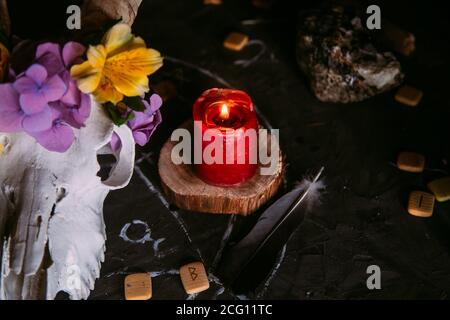 Gabbiano di capra bianco con corna, fiori, libro aperto vecchio, candele sul tavolo delle streghe. Concetto occulto, esoterico, divinazione e wicca. Halloween, giorno della dea Foto Stock