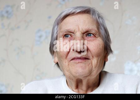 Donna anziana con espressione pacifica ha pensato a qualcosa. Donna felice con capelli grigi e pelle rugosa, concetto di ricordi, vecchiaia Foto Stock