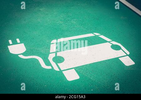 Simbolo del parcheggio sulla strada per le auto elettriche che vengono addebitate Foto Stock