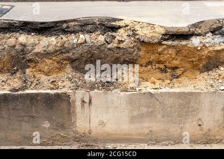 Vista dettagliata della sezione trasversale della strada cittadina con i livelli di ghiaia sabbia argillosa e asfalto come infrastruttura urbana Foto Stock