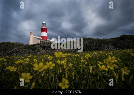 Faro di Capo Agulhas contro i cieli umorati, Sudafrica Foto Stock