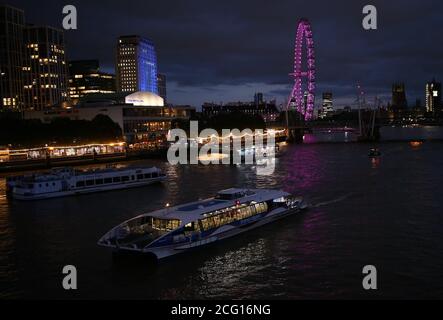 Una barca del Tamigi Clipper, quasi vuota, naviga oltre la South Bank sul Tamigi, nel centro di Londra. Foto Stock