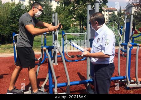 Ankara, Turchia. 8 Settembre 2020. Un poliziotto che indossa una maschera parla con un uomo in un parco ad Ankara, Turchia, l'8 settembre 2020. La Turchia ha confermato 1,761 nuovi casi COVID-19 martedì, portando il totale dei pazienti diagnosticati a 283,270, ha annunciato il Ministero della Salute turco. Credit: Mustafa Kaya/Xinhua/Alamy Live News Foto Stock