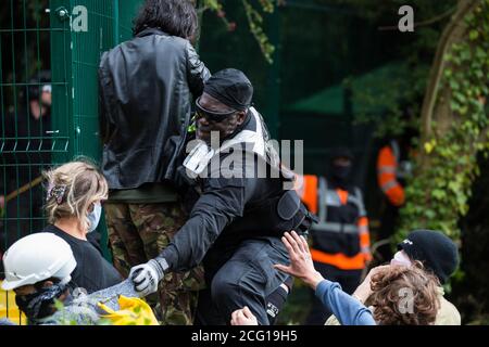 Denham, Regno Unito. 7 Settembre 2020. Un agente di applicazione del National Eviction Team afferra l'abbigliamento di un attivista della ribellione HS2 durante l'azione diretta da parte di attivisti anti-HS2 per prevenire o ritardare il taglio degli alberi in combinazione con il collegamento ferroviario ad alta velocità nel Denham Country Park. Gli attivisti anti-HS2 continuano a fare campagna e ad agire direttamente contro il controverso progetto £106 miliardi per il quale la fase di costruzione è stata annunciata il 4 settembre da una serie di campi di protezione basati lungo il percorso della linea tra Londra e Birmingham. Credit: Mark Kerrison/Alamy Live News Foto Stock