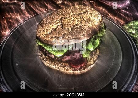 Un hamburger alla griglia con pomodori e insalata su un piatto. Foto Stock