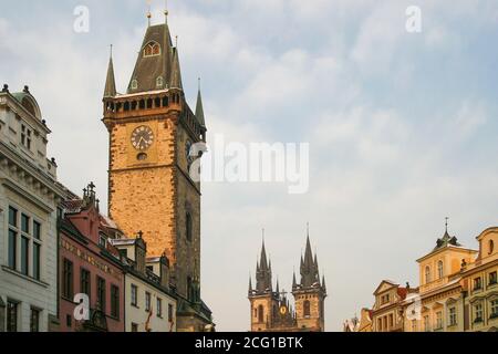 Edifici tetti storica Praga in inverno sera sole, torre dell'orologio Municipio di Praga (a sinistra) e torri nere della Chiesa di nostra Signora prima di Tyn. Foto Stock